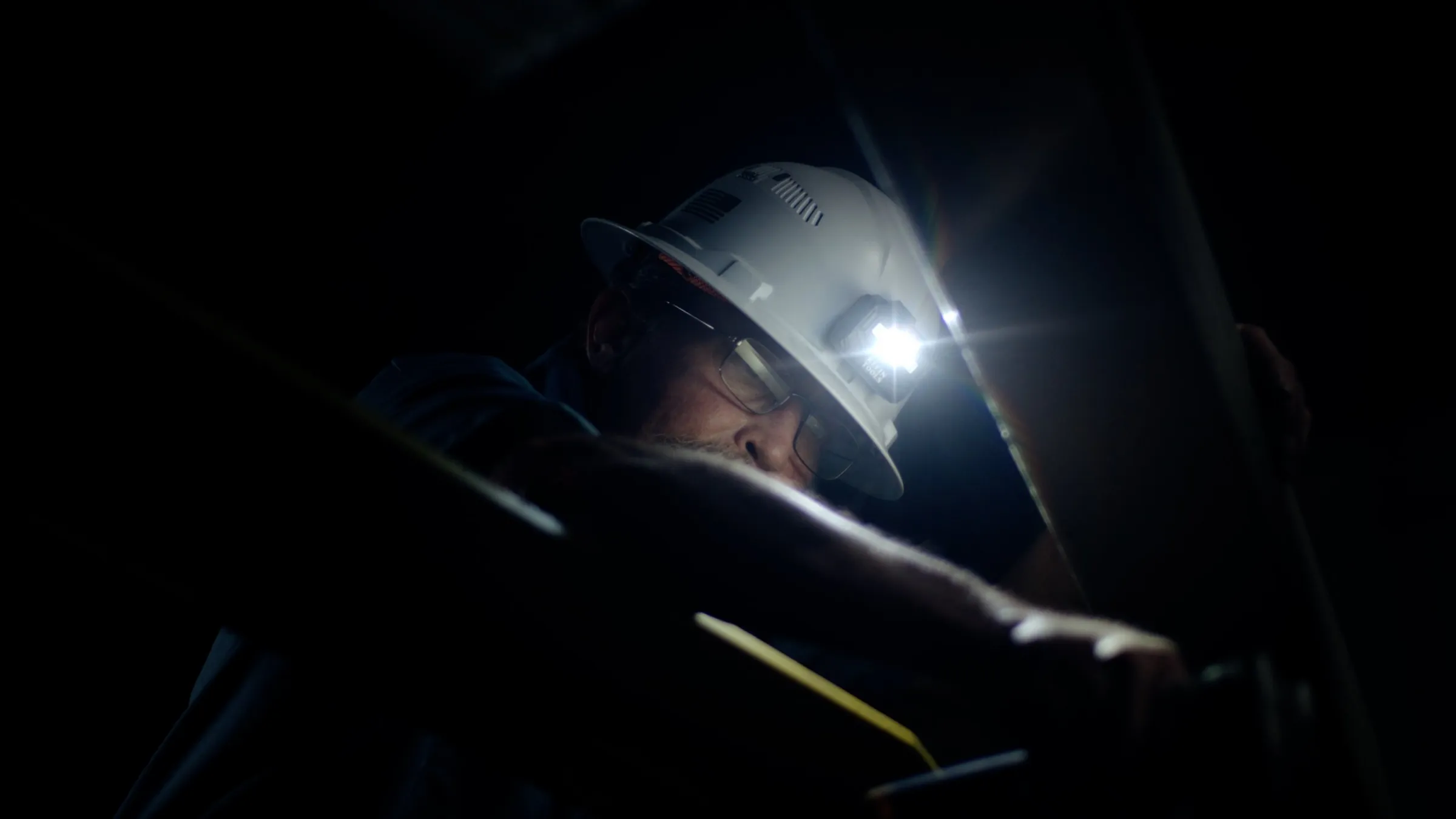 Welder at work, sparks lighting the mask, from a manufacturing brand video