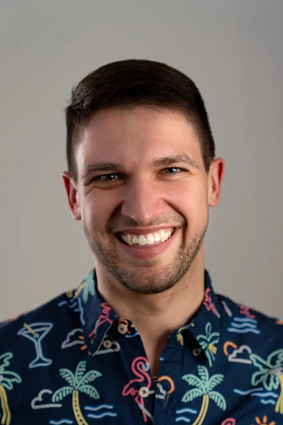 Corporate headshot of a smiling man in a patterned shirt